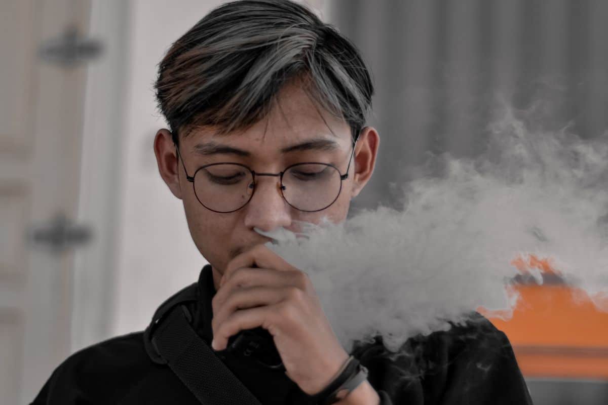 A guy vaping 3Chi's Comfortably disposable vape