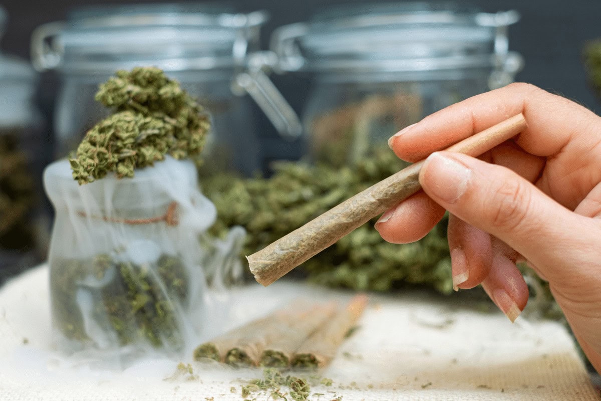 A woman holding a pre roll in her hand