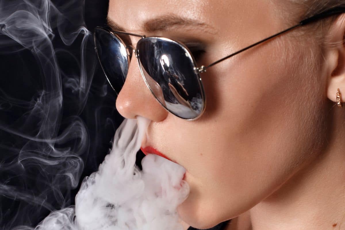 A lady trying french inhale weed smoking trick