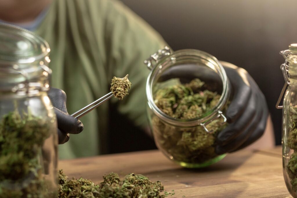 Person storing hemp products in glass jar
