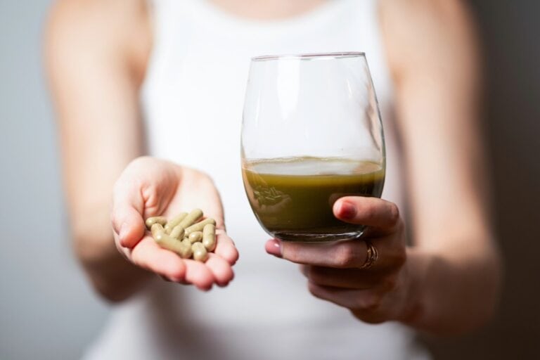 A lady is showing legal kratom capsules and a powdered kratom drink.